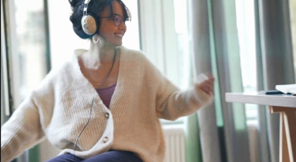 Kuva nuoresta naisesta kuulokkeet päässään